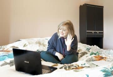 Woman Sitting on Bed with Laptop