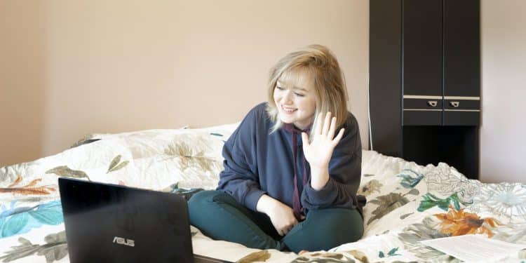 Woman Sitting on Bed with Laptop